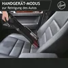 A person is using a handheld vacuum cleaner to clean a car seat. Produktbild-Vorschau