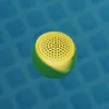 A yellow and green speaker floats on the surface of blue water. Náhľad obrázku produktu