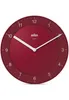 A red Braun wall clock with white hands and hour markers is shown against a white background. Náhľad obrázku produktu