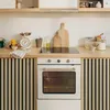 Weißer Einbauofen mit Glastür, integriert in eine moderne Küche mit Holzarbeitsplatten und Lamellenschränken Produktbild-Vorschau