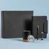 A set of office supplies including a notebook, pen, USB drive, and mug, arranged on a light blue background. Náhľad obrázku produktu