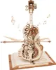 A 3D mechanical wooden model of a cello, intricately designed with gears and decorative elements, resting on an open book. Musical notes float around the cello, suggesting music and creativity. Voir les images du produit
