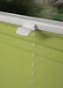 A close-up view of a light green pleated blind with a white clamp mechanism attached to the top. Produktbild-Vorschau