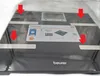 A black digital scale with a label showing product features and a display screen. Produktbild-Vorschau