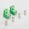 Two green electronic connectors and four silver hexagonal standoffs are arranged on a light gray background. Anteprima dell’immagine prodotto