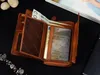 An open brown leather wallet with banknotes and cards inside, placed on a black surface. Náhľad obrázku produktu