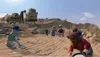 A group of Lego figures are in a desert landscape with a large excavator in the background. Náhled obrázku produktu