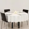 A round table set for a meal with white tablecloth, plates, glasses, and candles. Podgląd zdjęcia produktu