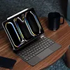 A tablet with a keyboard case and stylus sits on a wooden table next to a black mug. Anteprima dell’immagine prodotto