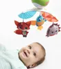 A baby looking up at a mobile with animal toys. Voir les images du produit