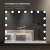 A makeup mirror with lights is placed on a shelf in front of a bed. Produktbild-Vorschau