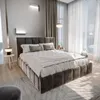 A bedroom with a large bed, curtains, and a window.