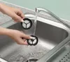 Hands washing reusable coffee filters in a sink under running water. Produktbild-Vorschau