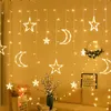 A room decorated with string lights shaped like stars and moons, with furniture and decorative items in the foreground. Produktbild-Vorschau