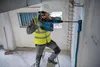 A construction worker is using a rotary hammer drill to make a hole in a concrete wall. Produktbild-Vorschau