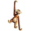 A wooden monkey toy hanging from its arm against a white background. Náhled obrázku produktu