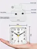 A white analog alarm clock is shown with dimensions and feature labels. Produktbild-Vorschau