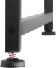 Close-up of a black metal table leg with an adjustable foot and a pink spring. Náhled obrázku produktu