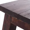 A close-up view of the corner of a dark brown wooden stool. Produktbild-Vorschau