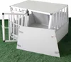A white dog crate with its door open, sitting on a green surface that resembles artificial grass. Voir les images du produit