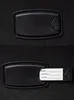 A close-up of a black luggage tag attached to a black suitcase. Produktbild-Vorschau