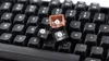 Close-up view of several detached keycaps on a black mechanical keyboard. Podgląd zdjęcia produktu