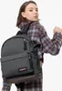 A young woman wearing a plaid shirt is modeling a gray Eastpak Wyoming Black Denim Rucksack. Produktbild-Vorschau