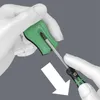 Hands using a screwdriver to interact with a green tool accessory. Produktbild-Vorschau