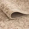 A close-up view of a rolled-up rug, showing its texture and abstract pattern. Voir les images du produit