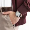 A person's hand wearing a watch is placed in the pocket of their pants. Produktbild-Vorschau