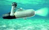 A white Aqua Marina BlueDrive X PRO Power Fin underwater scooter with a green light beam is shown in clear blue water. Podgląd zdjęcia produktu