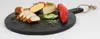 A black wooden serving board with various food items arranged on it, including cheese, bread, cucumber slices, and a red pepper. Anteprima dell’immagine prodotto