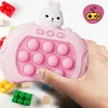 A hand is holding a pink electronic toy with a rabbit on top, surrounded by building blocks. Produktbild-Vorschau