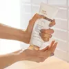 A person is dispensing a hair treatment from a tube into their hand. Anteprima dell’immagine prodotto