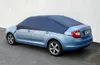 A light blue car is covered with a dark blue car cover. Náhled obrázku produktu