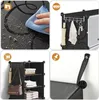 A collage of four images showcasing a black modular shoe storage unit. The top left shows a hand cleaning the surface. The top right shows the unit with hooks holding an umbrella, a towel, and keys. The bottom left shows the unit with books, folded clothes Voir les images du produit