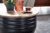 A close-up of a round coffee table with a wooden top and a black ribbed base, decorated with a small potted plant and a coffee cup. Voir les images du produit