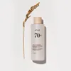 A bottle of Anua Rice 70+ Ceramide Glow Milky Toner is placed next to a dried stalk of rice on a white background. Náhľad obrázku produktu