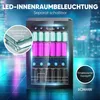 A Bomann® beverage cooler is shown with its interior LED lighting illuminated, displaying rows of cans and bottles. The background features a blurred cityscape and a reflective floor. Anteprima dell’immagine prodotto