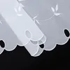 A close-up view of a white sheer curtain with embroidered leaf patterns and a scalloped, cut-out hem. Produktbild-Vorschau