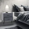 A bedroom scene with a nightstand and bed. Produktbild-Vorschau