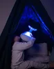 A child sits inside a dark tent holding a glowing whale toy. Anteprima dell’immagine prodotto