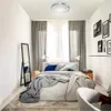A bedroom scene with a bed, curtains, a mirror, and a ceiling light. Produktbild-Vorschau