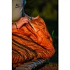 A person is sitting outdoors with a sleeping bag. Anteprima dell’immagine prodotto