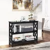 A black three-tier console table with decorative X-shaped sides, placed in a room setting with a rug and artwork on the wall. Podgląd zdjęcia produktu