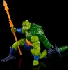 A green, reptilian action figure with an orange spear against a black background. Náhled obrázku produktu