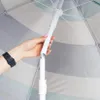 A hand holding the pole of a beach umbrella. Náhled obrázku produktu