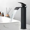 A modern black waterfall faucet is shown in use over a decorative sink. Produktbild-Vorschau