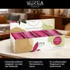 A box of Veertea premium tea bags displayed on a table, with a blurred living room background. Produktbild-Vorschau