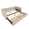 A beige upholstered bed frame with a slatted base, pulled out to reveal storage drawers underneath. The bed is shown from a slightly elevated, diagonal angle against a white background. Náhled obrázku produktu
